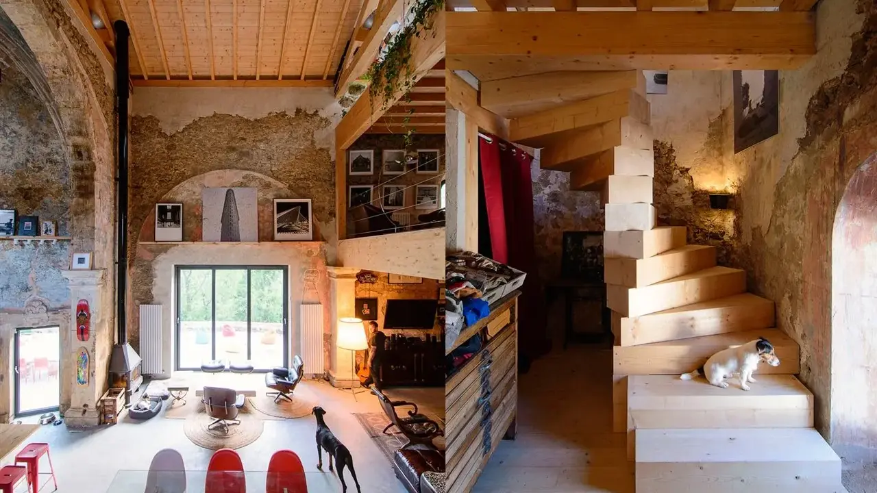 Estudio de diseño interior con escaleras de madera, perros y mobiliario ecléctico.