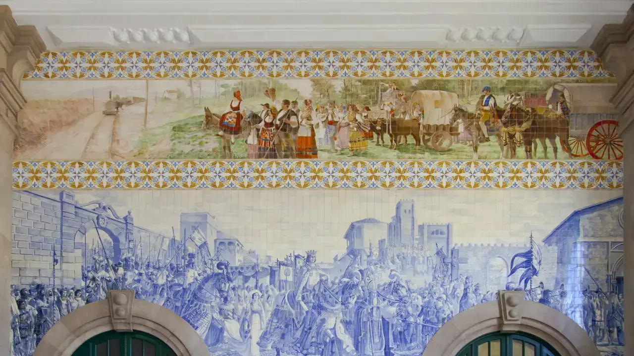 Azulejos de Oporto narran la historia: un tren antiguo, gente vestida de época y una procesión militar en azul y blanco.