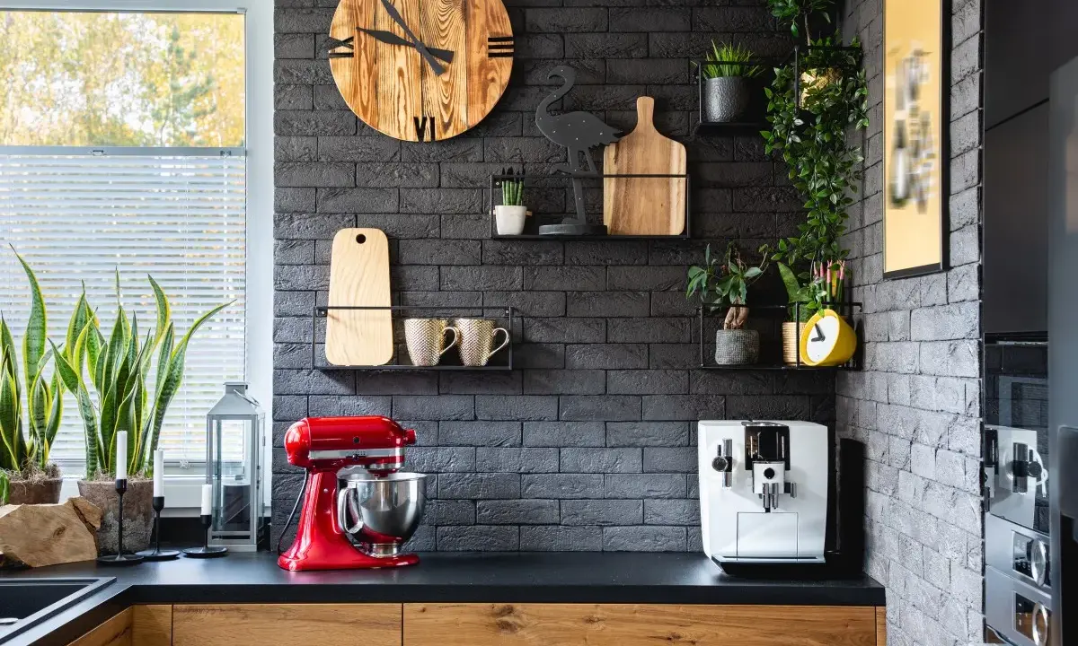 Estilo moderno para la decoracion pared cocina: reloj de madera, plantas, tazas y batidora roja.