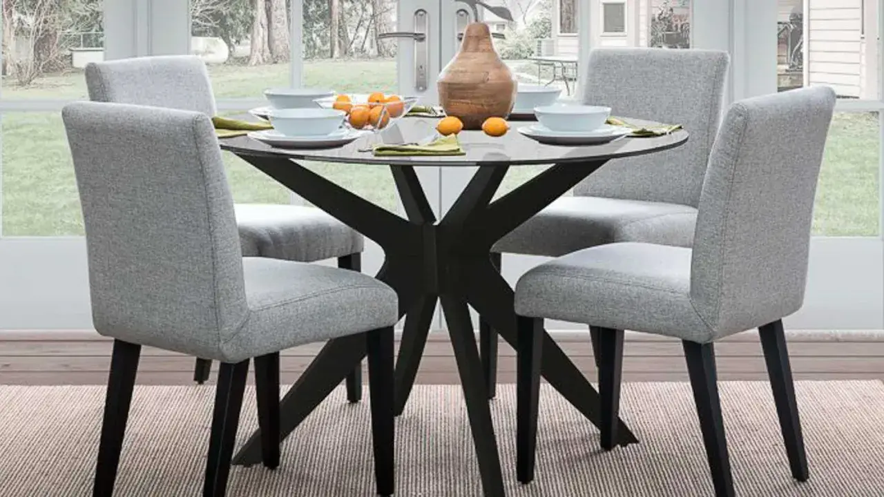 Ideas para decorar una mesa redonda: centro de mesa con jarrón y naranjas, platos y servilletas.