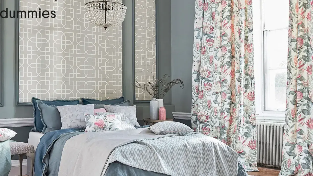 Cama elegante con ropa de cama azul y cojines florales, cortinas de proteas y papel tapiz geométrico. Un kilim Maimana aportaría calidez a este espacio.