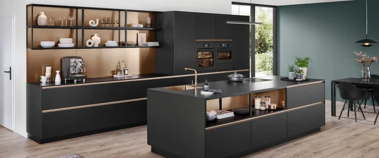 Elegantes cocinas pequeñas con isla central negra, gabinetes dorados y electrodomésticos integrados.