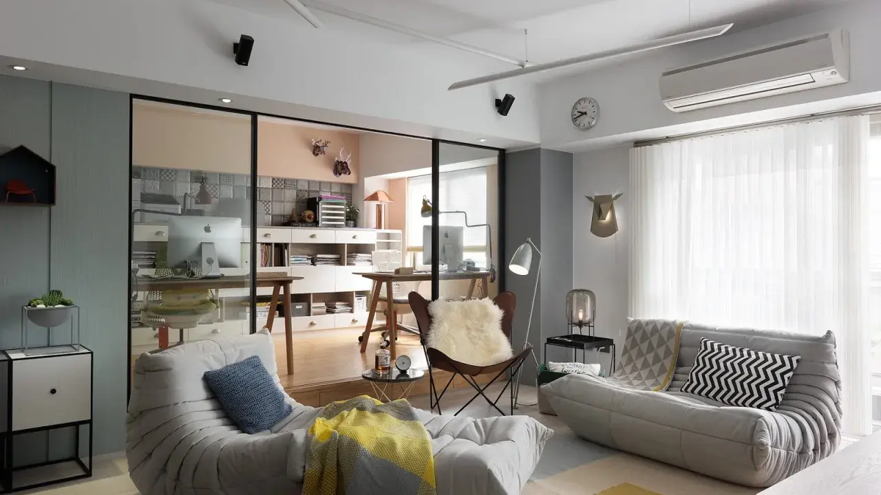 Un espacio que irradia hygge que es: sofás cómodos, mantas cálidas y un rincón de trabajo acogedor.