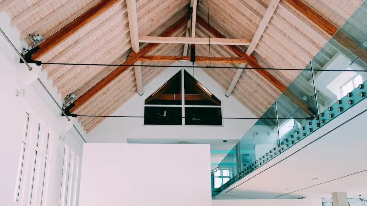 Techo interior con vigas de madera y un moderno **aislante térmico para techos interiores** que complementa la arquitectura.