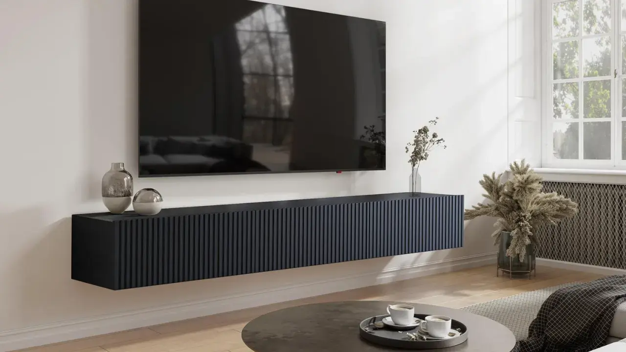 Un mueble flotante oscuro para salón, con un gran televisor encima. El mueble es demasiado estrecho para el tv no cabe en mueble salón.