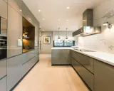 Elegantes diseños de cocinas modernas pequeñas, con gabinetes grises brillantes, encimeras blancas y electrodomésticos integrados.
