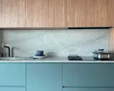 Elegantes gabinetes turquesas y encimeras de mármol gris, perfectos como colores para cocinas pequeñas.