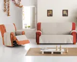 Fundas de sofá Eysa en tonos neutros y naranjas, cubriendo un sillón reclinable y un sofá de dos plazas en un salón luminoso.