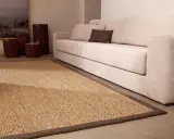Alfombra sisal 200x300 de fibras naturales, ideal para crear un ambiente cálido y acogedor junto a un sofá beige.
