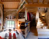 Estudio de diseño interior con escaleras de madera, perros y mobiliario ecléctico.