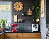 Estilo moderno para la decoracion pared cocina: reloj de madera, plantas, tazas y batidora roja.