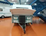 Compartimentos para decorar caravana por dentro. Almacenamiento organizado con cubos blancos y un depósito negro.