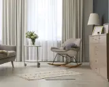 Elegantes cortinas de salón, mecedora beige y cómoda de madera. Las últimas tendencias en cortinas para tu salón.