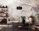 Sofá gris, mesa negra y estantería metálica en una sala con decoración estilo industrial chic. Pared texturizada y silla naranja.