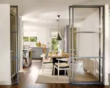 Separación pared cristal cocina salón. Una puerta corredera de cristal divide la cocina del salón, creando un espacio abierto y luminoso.