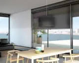 Comedor moderno con vistas al mar, decorado con estores Bandalux que controlan la luz.