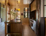Cocina de lujo con isla de mármol, electrodomésticos de acero inoxidable y detalles en vidrio de colores. Una clara tendencia en cocinas modernas y sofisticadas.