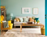 Un sillón amarillo vibrante y cojines con estampados alegres muestran los **colores que combinan con mostaza** en esta sala de estar acogedora.