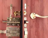 Detalle de varios tipos de pestillos para puertas de madera, con acabados dorados y plateados, incluyendo manijas.