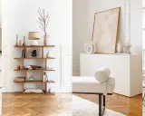 Estancias luminosas con muebles modernos y decorativos sobre una **pared blanca**. Jarrones, libros y arte añaden estilo.
