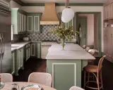 Elegantes cocinas verdes con gabinetes de madera clara, encimeras de mármol y un toque de color en la campana de la estufa.