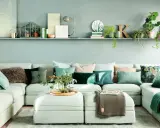 Sofá modular verde agua con cojines en tonos tierra y verdes, creando un ambiente sereno.