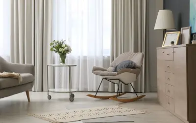 Elegantes cortinas de salón, mecedora beige y cómoda de madera. Las últimas tendencias en cortinas para tu salón.
