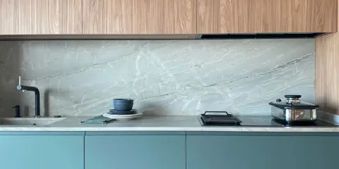 Elegantes gabinetes turquesas y encimeras de mármol gris, perfectos como colores para cocinas pequeñas.