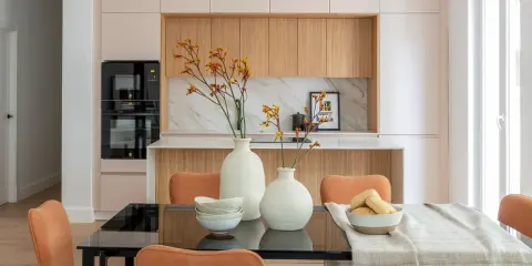 Dos jarrones con flores secas, cuencos apilados y un bol con panecillos son perfectos para poner encima de una mesa de comedor.