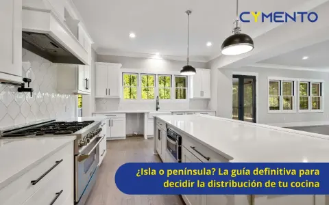 Cocina moderna y luminosa con una espaciosa isla central, gabinetes blancos y electrodomésticos de acero inoxidable.