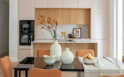 Dos jarrones con flores secas, cuencos apilados y un bol con panecillos son perfectos para poner encima de una mesa de comedor.