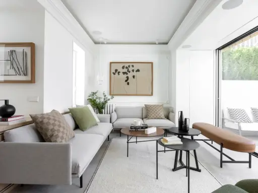 Salón moderno y luminoso con grandes ventanales que permiten unir terraza y salón, creando un espacio fluido y acogedor.