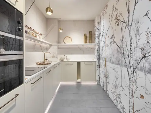 Cocinas pequeñas con encanto: gabinetes color crema, encimeras de mármol, electrodomésticos Siemens y un papel tapiz de bosque invernal.