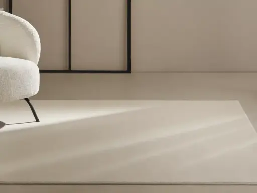 Un espacio moderno con sillones blancos y alfombras de lana a medida, bañadas por la luz natural.