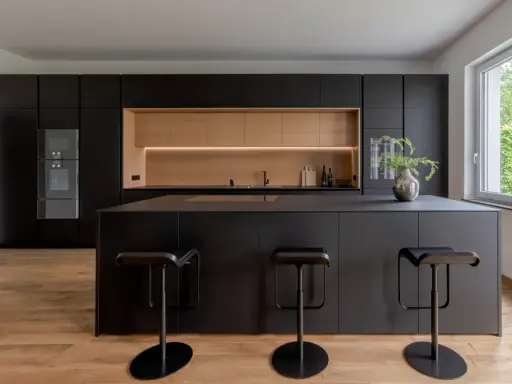 Elegantes cocinas negras y madera, con isla central y taburetes modernos.