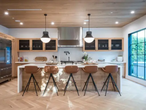Cocina moderna con isla central y taburetes de cuero marrón. Las medidas del taburete son ideales para la altura de la isla.