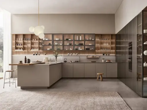 Cocina con península abierta al salón, con estanterías de madera y electrodomésticos integrados.