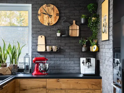 Estilo moderno para la decoracion pared cocina: reloj de madera, plantas, tazas y batidora roja.