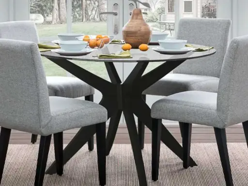 Ideas para decorar una mesa redonda: centro de mesa con jarrón y naranjas, platos y servilletas.