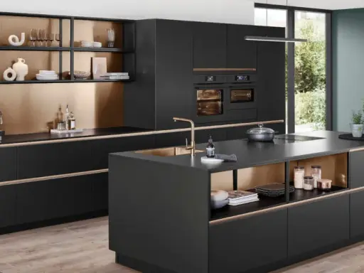 Elegantes cocinas pequeñas con isla central negra, gabinetes dorados y electrodomésticos integrados.