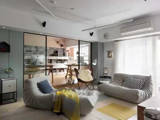 Un espacio que irradia hygge que es: sofás cómodos, mantas cálidas y un rincón de trabajo acogedor.