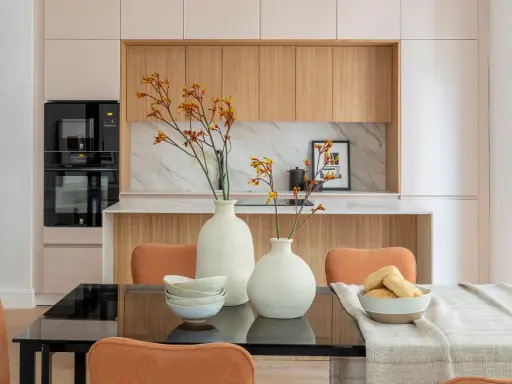 Dos jarrones con flores secas, cuencos apilados y un bol con panecillos son perfectos para poner encima de una mesa de comedor.