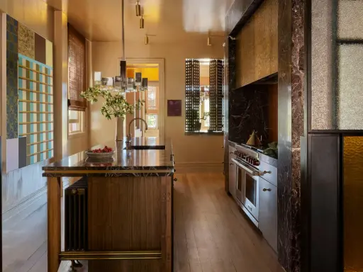 Cocina de lujo con isla de mármol, electrodomésticos de acero inoxidable y detalles en vidrio de colores. Una clara tendencia en cocinas modernas y sofisticadas.