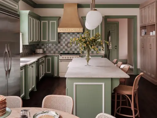 Elegantes cocinas verdes con gabinetes de madera clara, encimeras de mármol y un toque de color en la campana de la estufa.