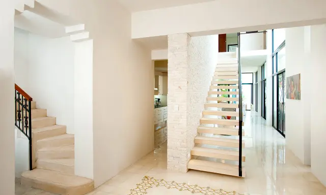 Pasillos con encanto, con escaleras de diseño moderno y clásico, y un suelo de baldosas con motivos dorados.