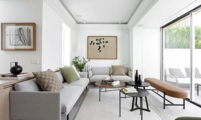 Salón moderno y luminoso con grandes ventanales que permiten unir terraza y salón, creando un espacio fluido y acogedor.