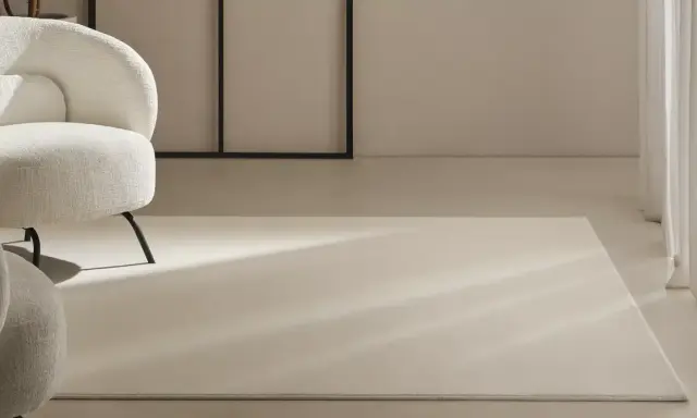 Un espacio moderno con sillones blancos y alfombras de lana a medida, bañadas por la luz natural.