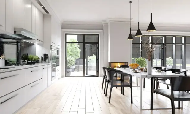Cocina moderna con encimera de mármol negro y **suelos para cocinas sin obras** de madera clara. Mesa de comedor con sillas negras y chimenea.