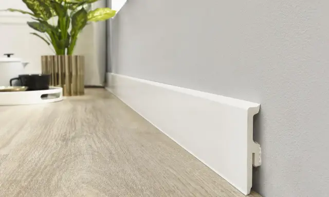 Rodapiés blancos modernos, un detalle clave en la decoración actual. Su diseño minimalista realza la calidez de la madera del suelo.