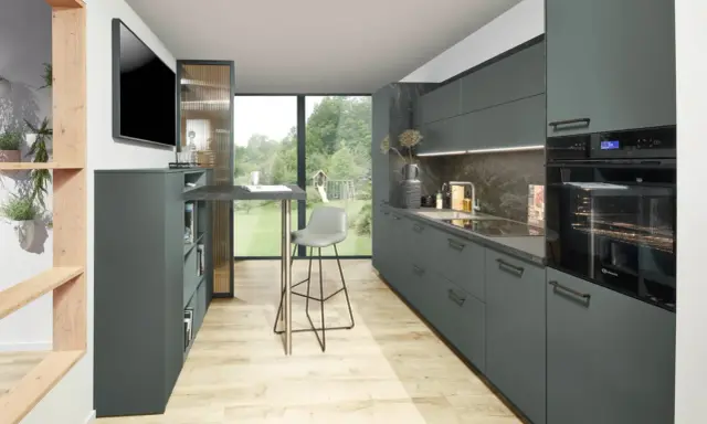 Elegante cocina con gabinetes grises y encimera de piedra. La combinacion colores para cocina es moderna y sofisticada, con toques de madera natural.